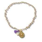 Gold anklet with charms on a white background