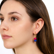 Close-up of a woman wearing colorful earrings on a white background
