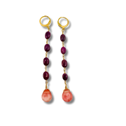 Pair of earrings with gold hooks, purple beads, and pink stones on a white background