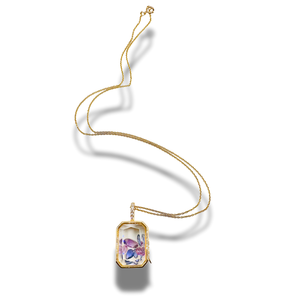 Gold necklace with a rectangular pendant on a white background