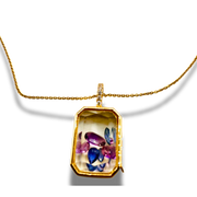 Gold necklace with a pendant featuring colorful gemstones on a white background
