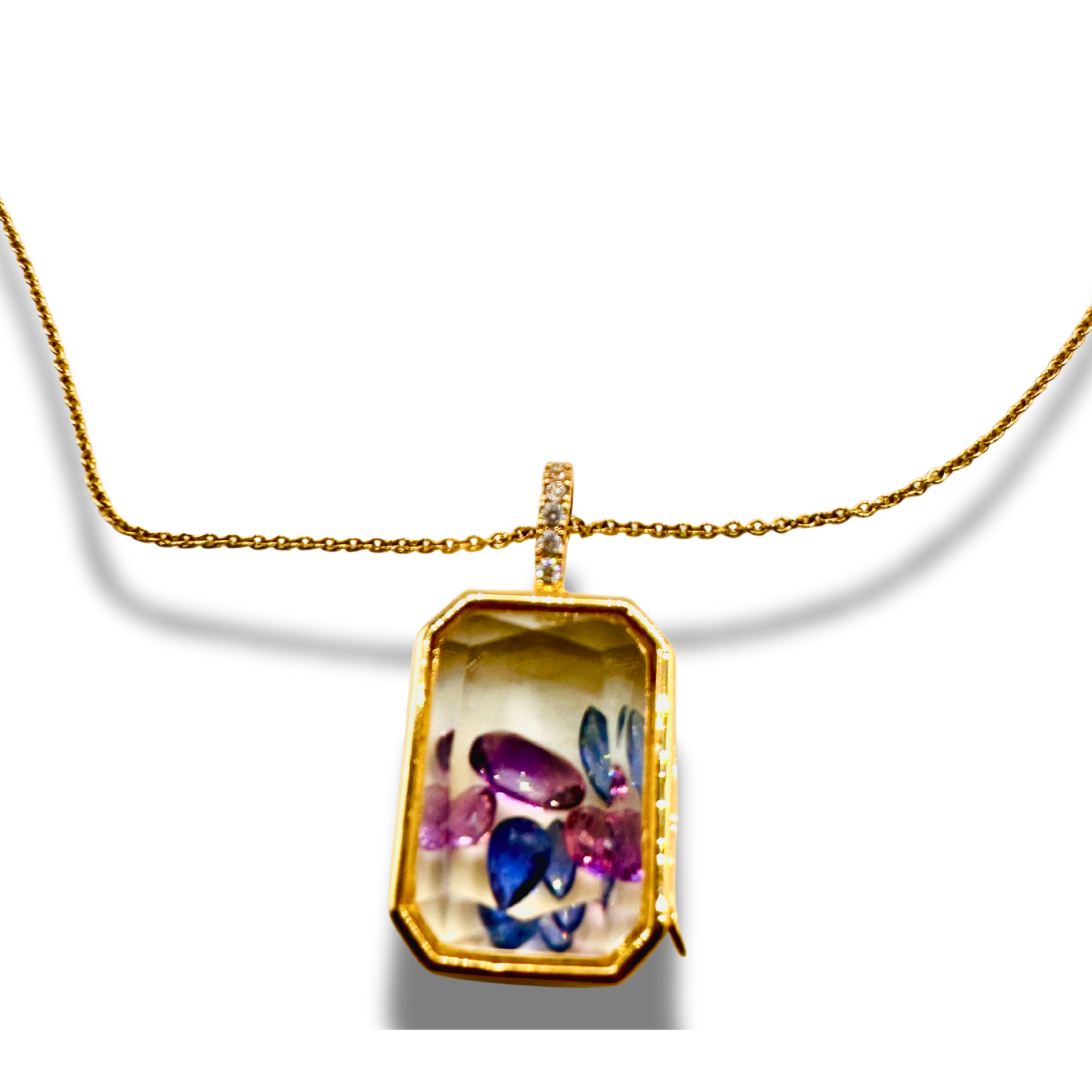 Gold necklace with a pendant featuring colorful gemstones on a white background