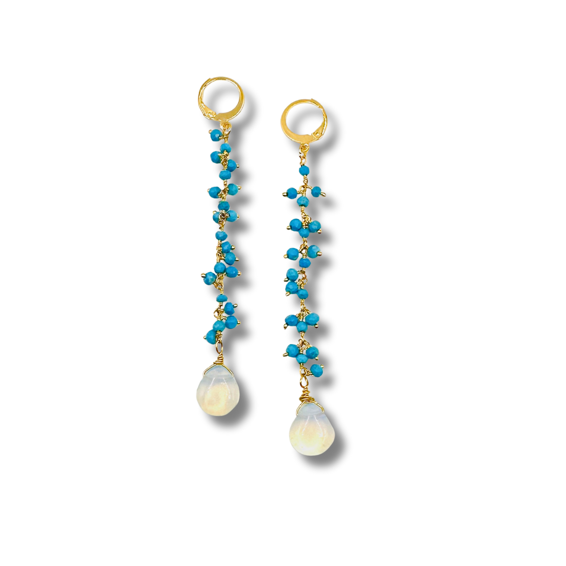 Pair of earrings with turquoise beads and gold accents on a white background