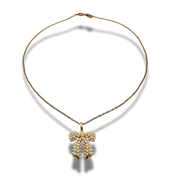 Gold necklace with a bow-shaped pendant on a white background