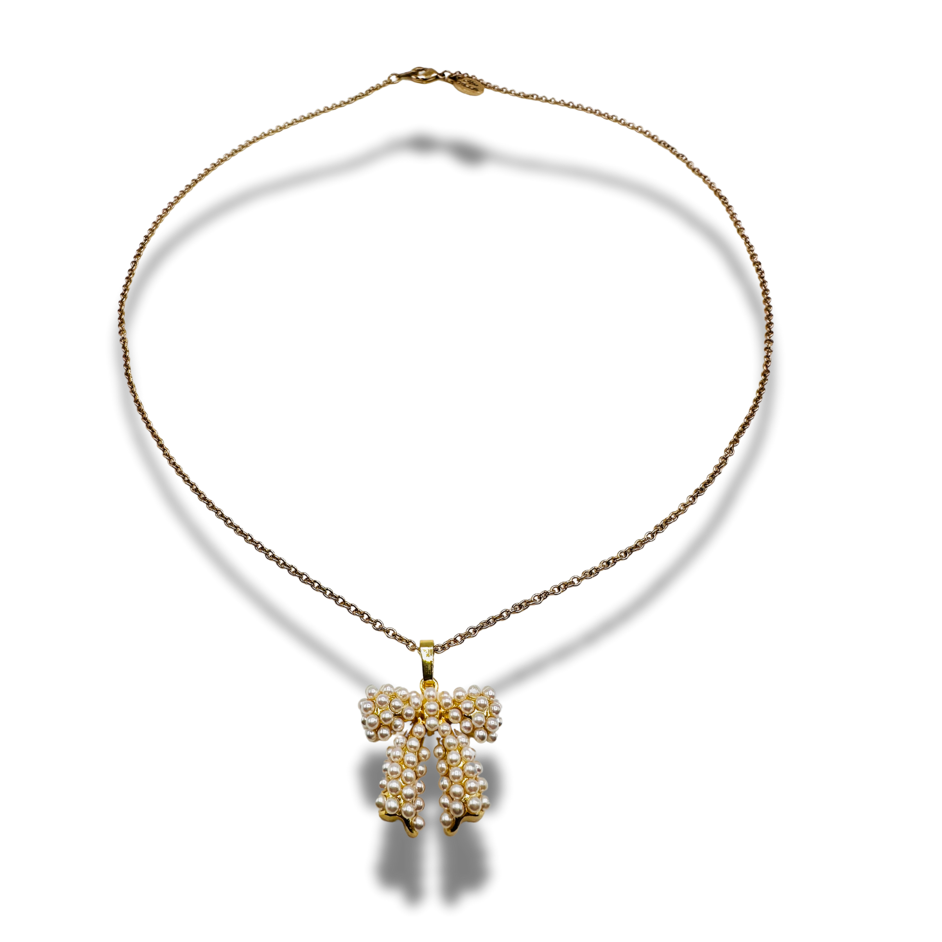 Gold necklace with a bow-shaped pendant on a white background