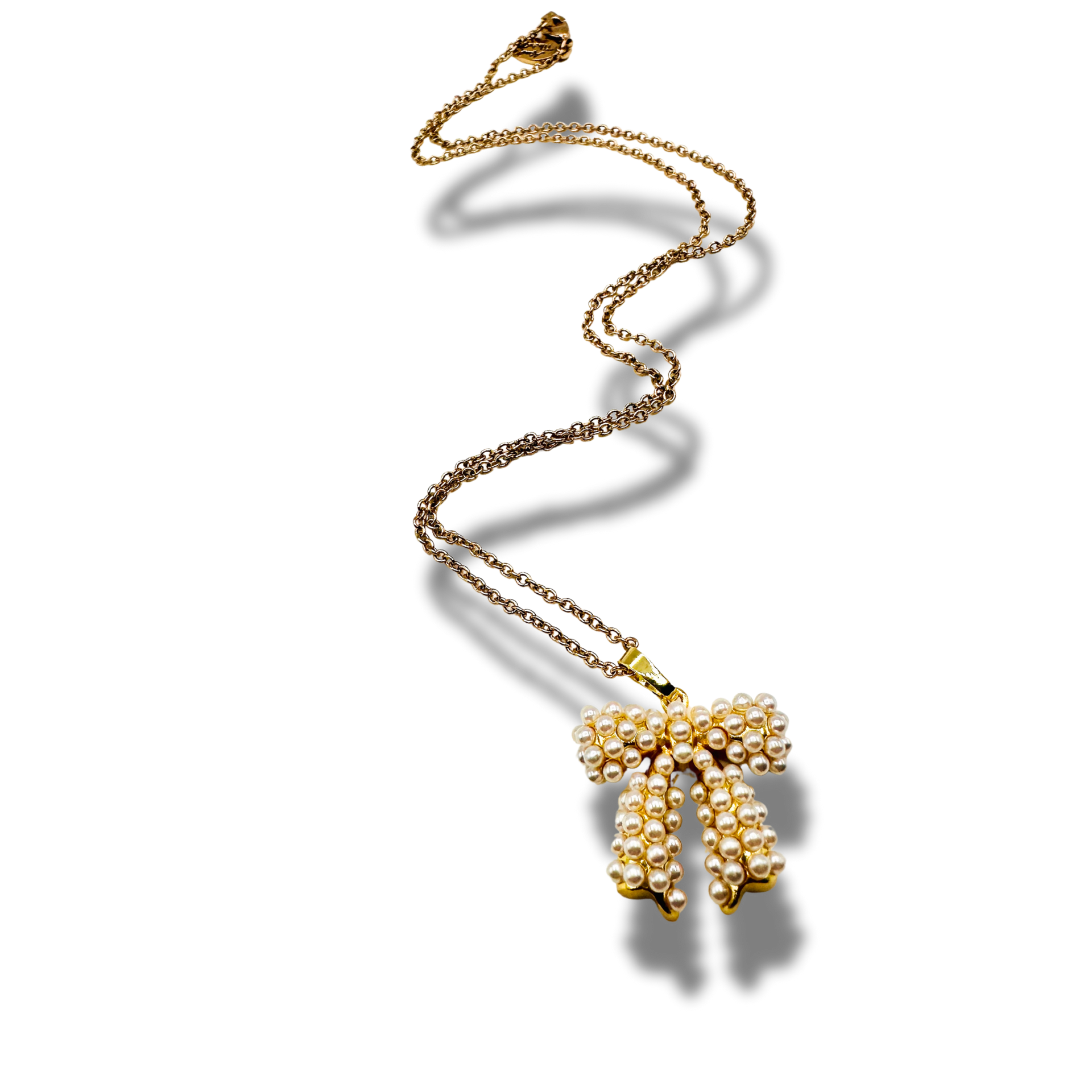 Gold necklace with a bow-shaped pendant on a white background