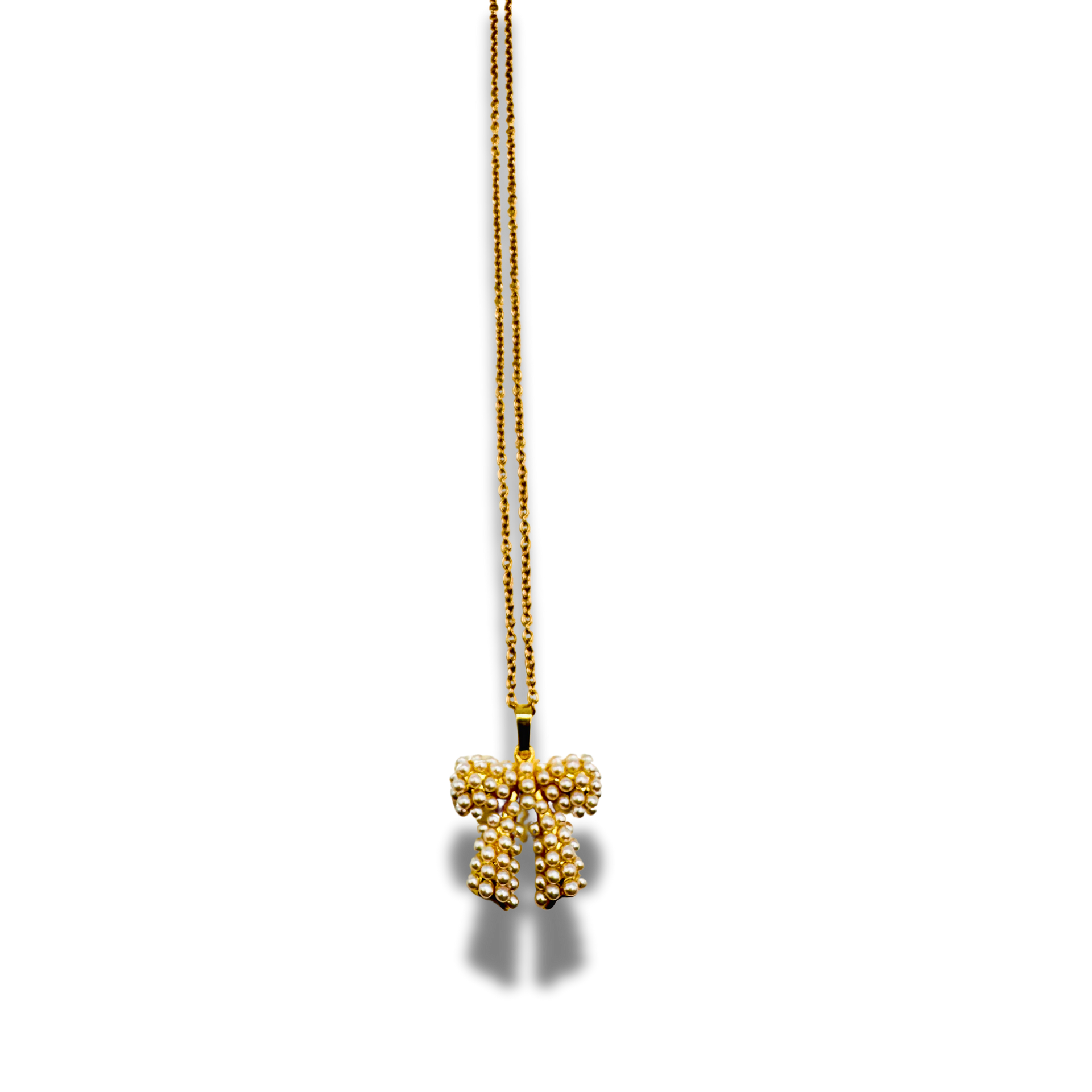 Gold necklace with a bow-shaped pendant on a white background