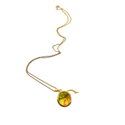 Gold necklace with a green gemstone pendant on a white background