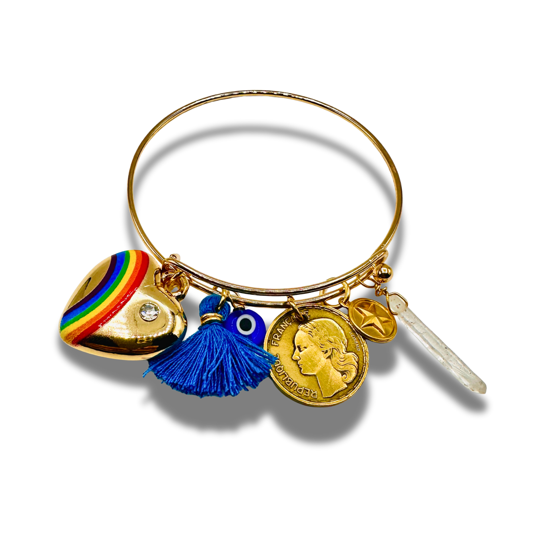 Gold bracelet with various charms including a rainbow heart, blue tassel, and coin on a white background