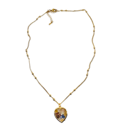 A gold chain necklace featuring a heart-shaped pendant with a colorful, textured inlay, displayed against a solid white background.