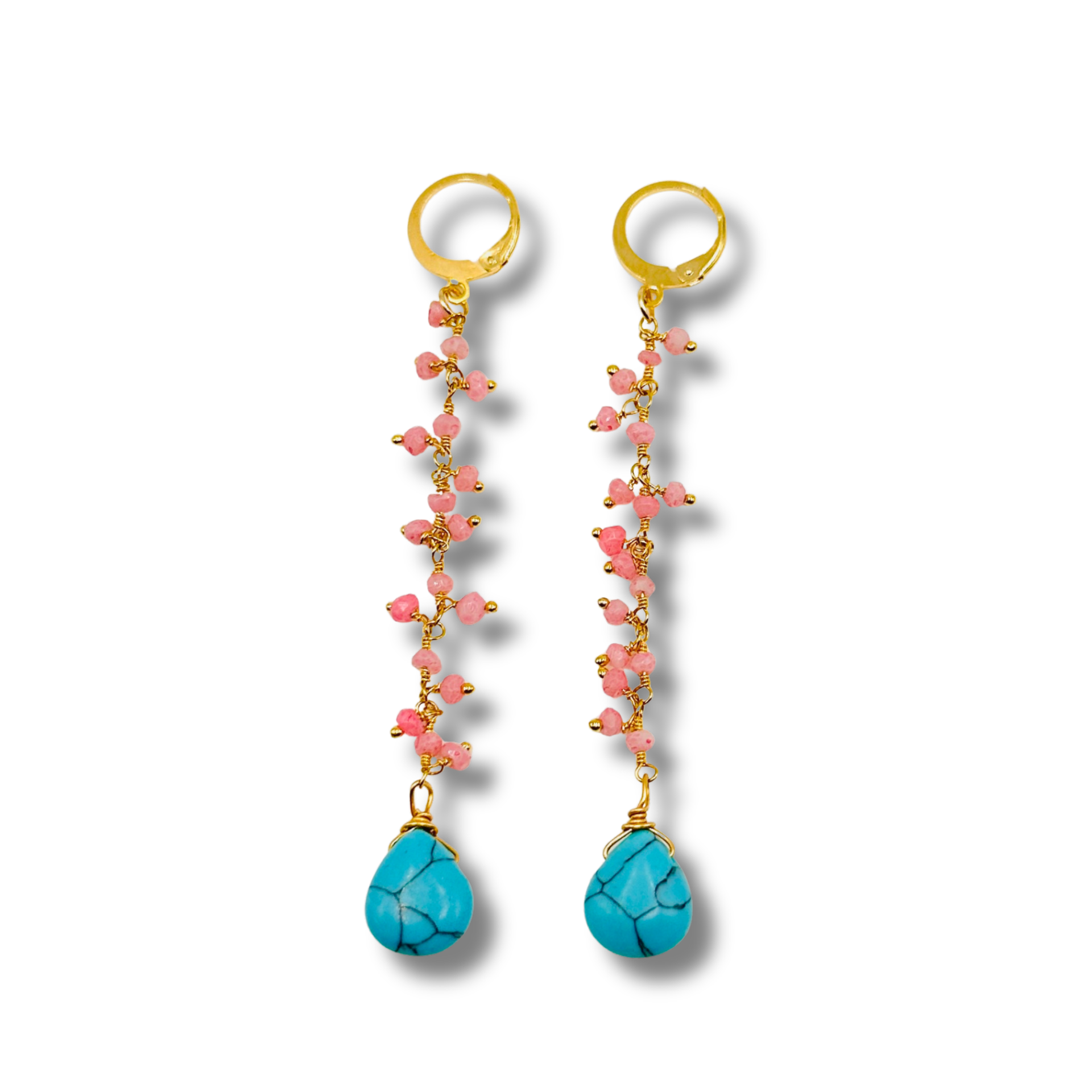 Pair of earrings with gold beads, pink stones, and turquoise drops on a white background