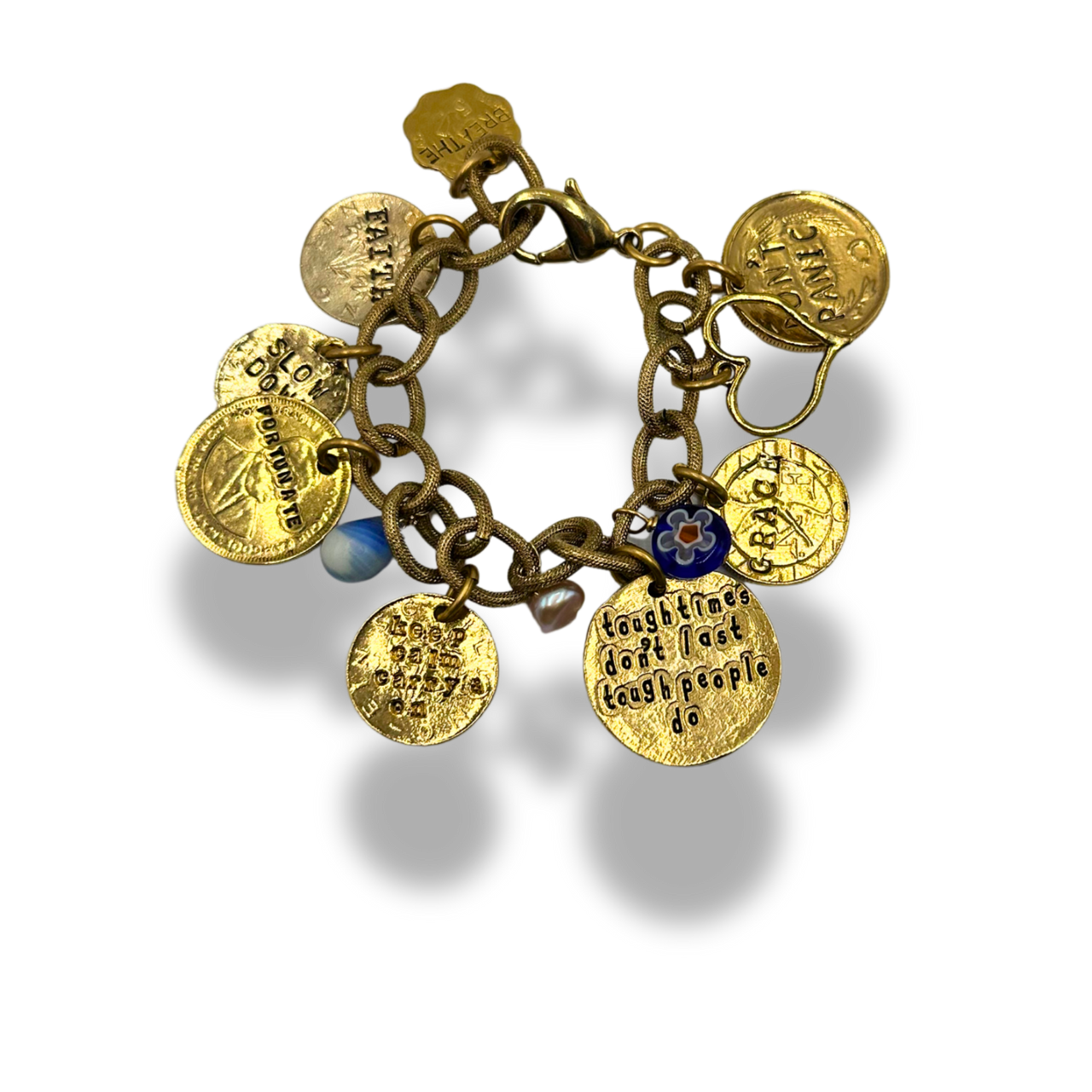 A gold charm bracelet with multiple engraved round medallion charms, a small blue bead, and a floral accent, shown on a white background with a soft shadow.
