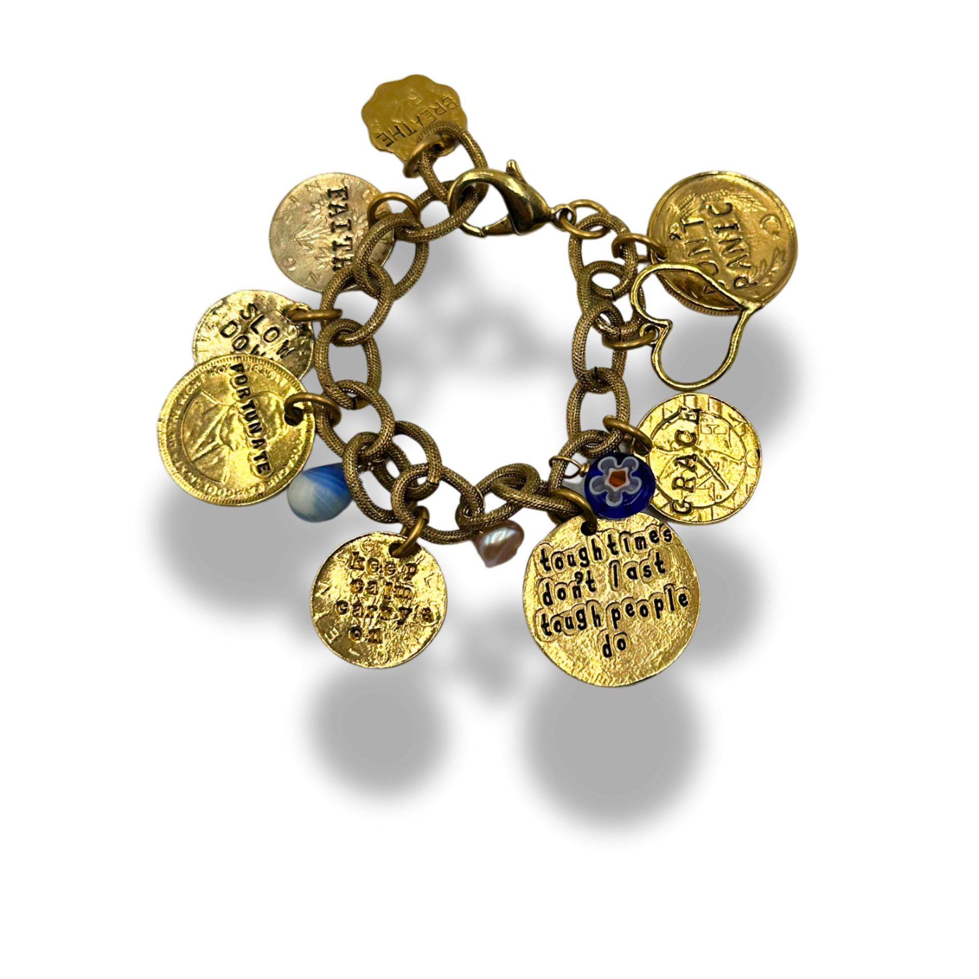 A gold charm bracelet with multiple engraved round medallion charms, a small blue bead, and a floral accent, shown on a white background with a soft shadow.