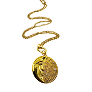 Gold necklace with a face pendant on a white background