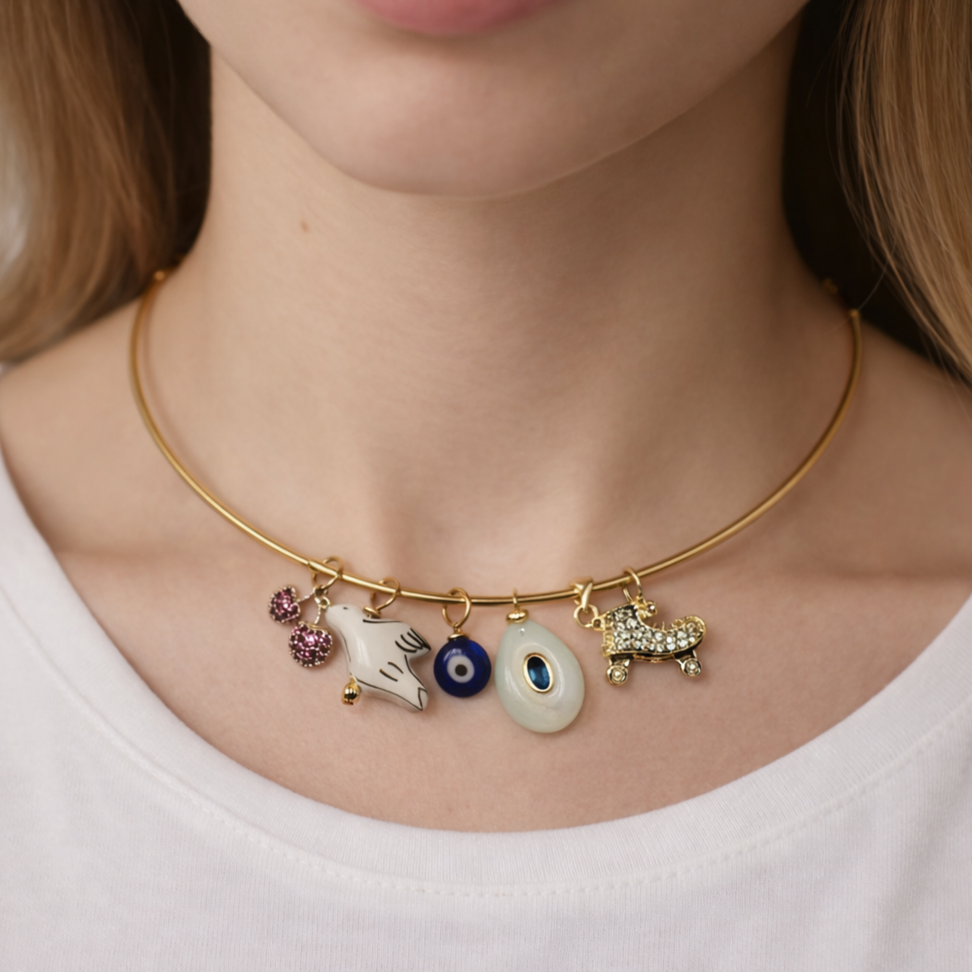 Necklace with charms worn by a person on a plain background