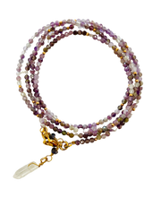 A faceted amethyst bead necklace with a clear crystal point and gold accents, intended for cleansing and spiritual enhancement.