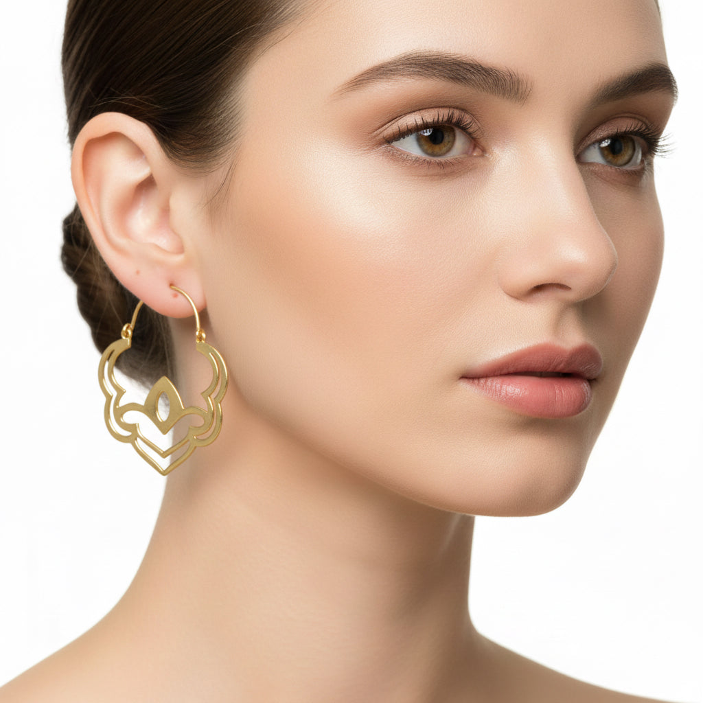 Close-up of a woman wearing gold earrings on a white background
